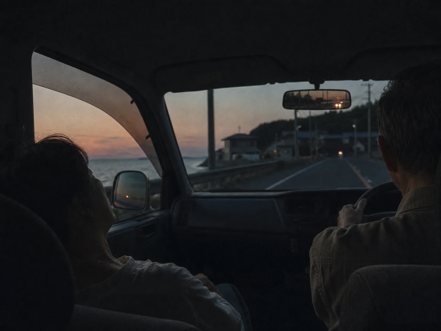 夕暮れの海沿いを帰る車内。母が眠り、父が運転している